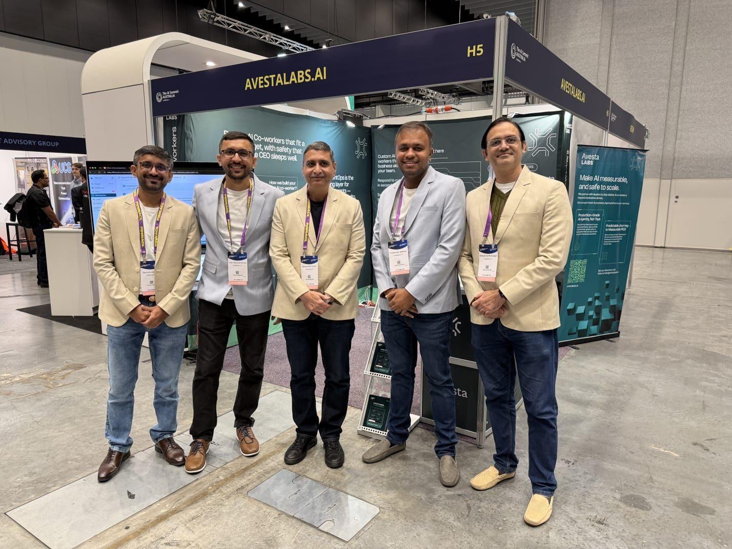 Five members of the Avesta Labs team standing shoulder to shoulder in front of their stand at The AI Summit Australia 2026 in Melbourne, under an overhead fascia reading AVESTALABS.AI with the stand number H5 at its right-hand end